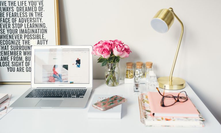 Skrivepult med utstyr som laptop, PC og skriveblokker.